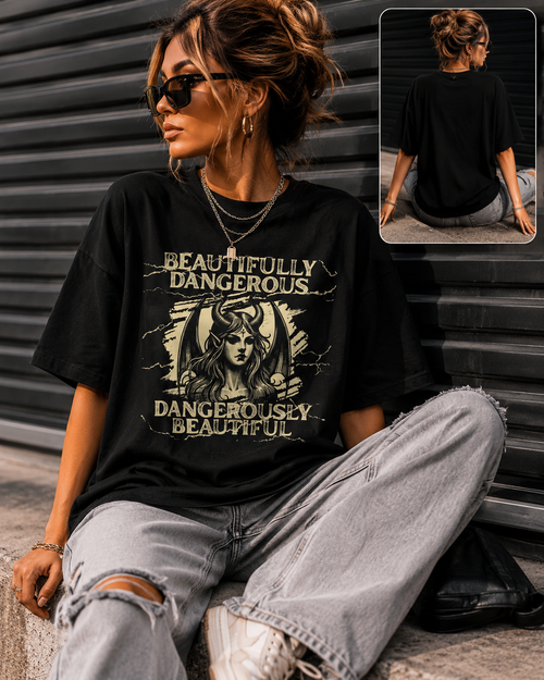 Woman wearing a Beautifully Dangerous graphic t-shirt with gothic fantasy artwork, black unisex graphic tee styled with distressed jeans and an oversized streetwear fit.